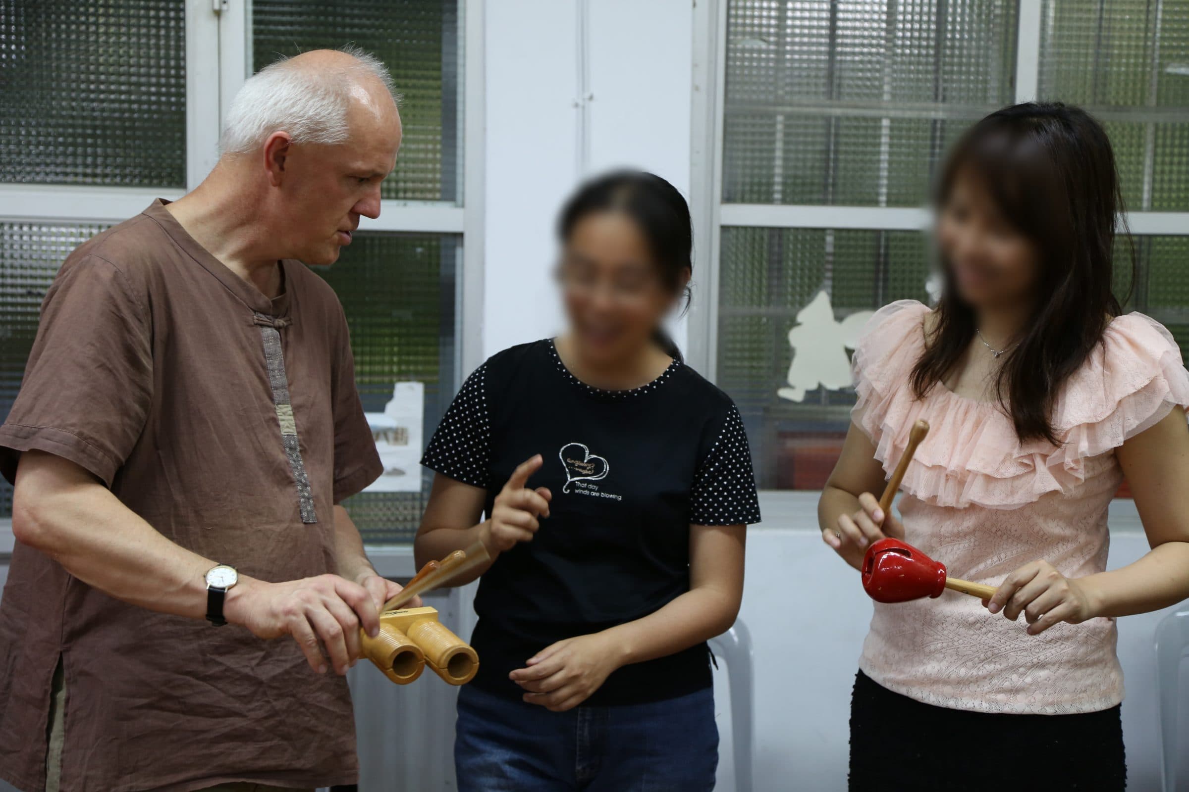 Markus Weiss showing bamboo instruments to two workshop participants