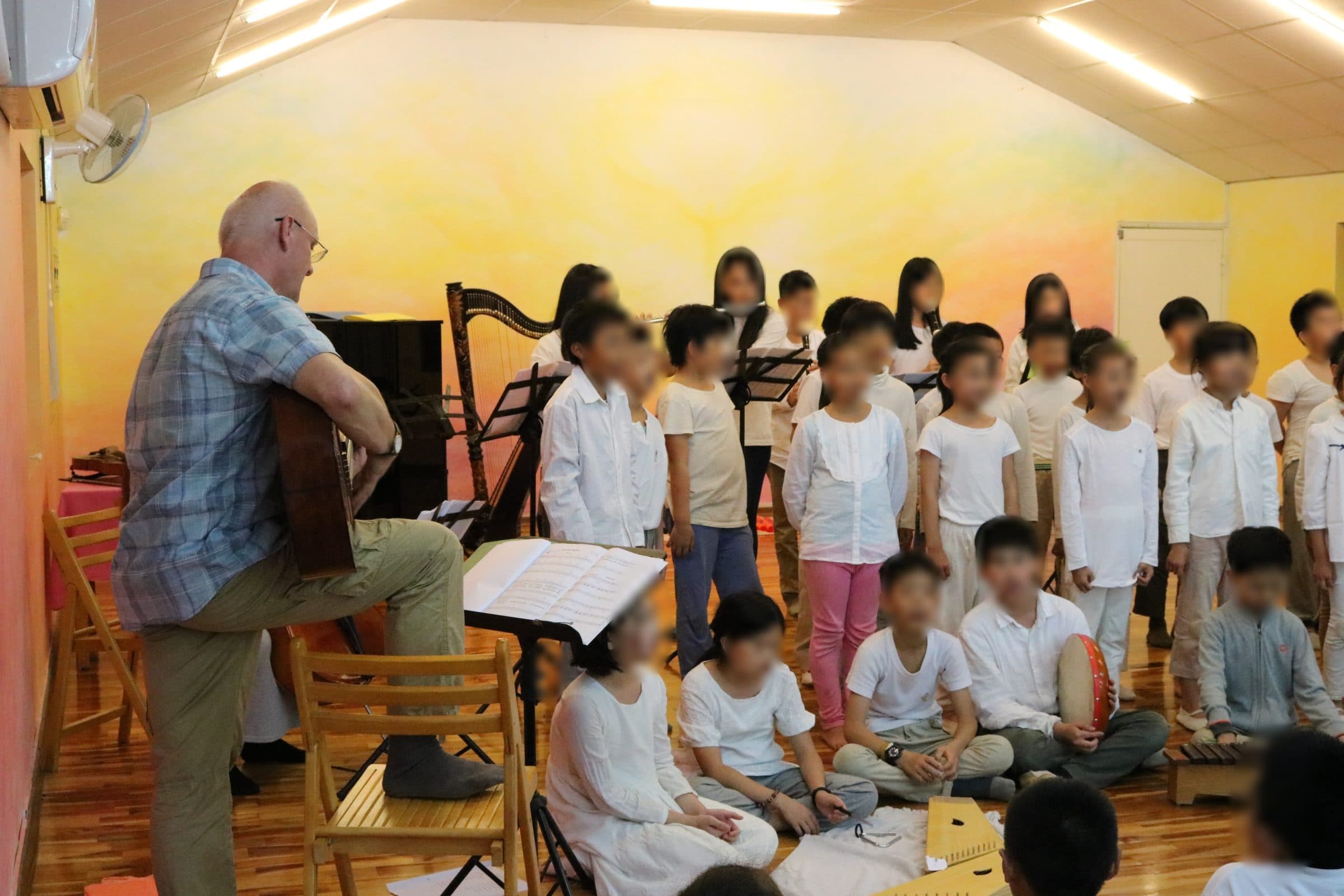 Children's choir singing while Markus Weiss accompanies on guitar